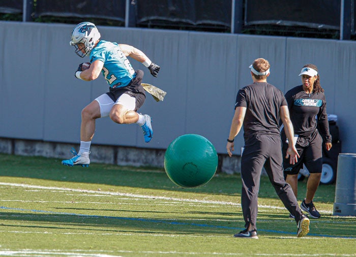 Christian McCaffrey of the Carolina Panthers jumps over Tre